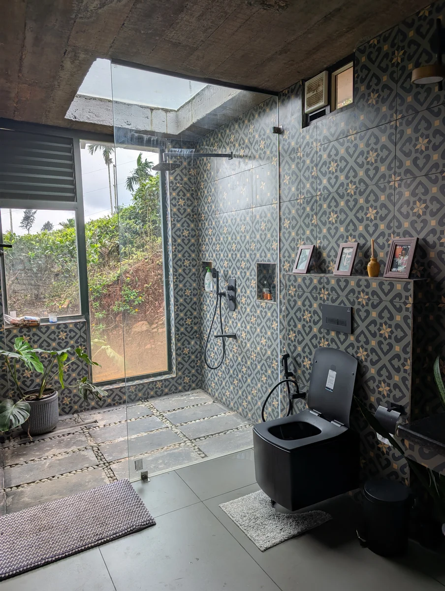 A stone bathroom with a window overlooking greenery