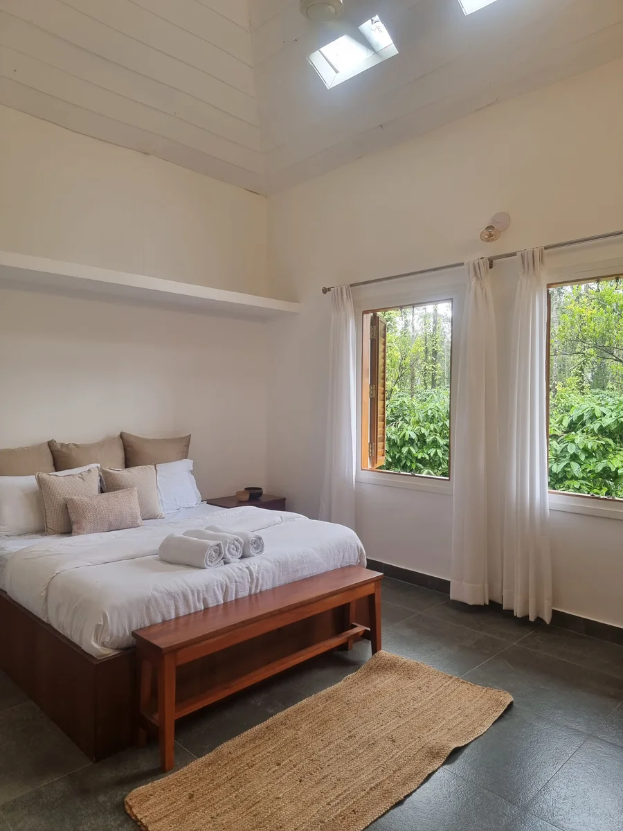 A bright bedroom opening onto greenery