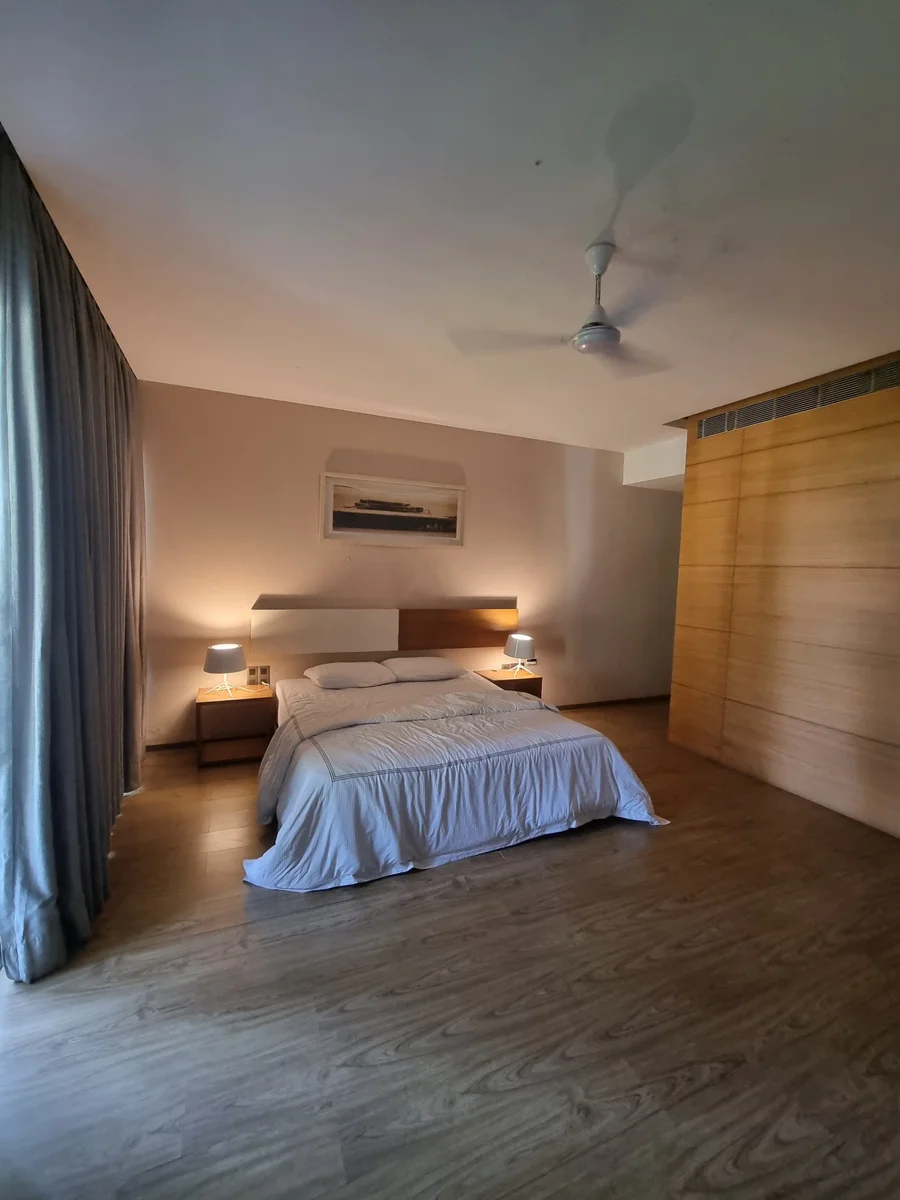 A softly lit bedroom with blue curtains