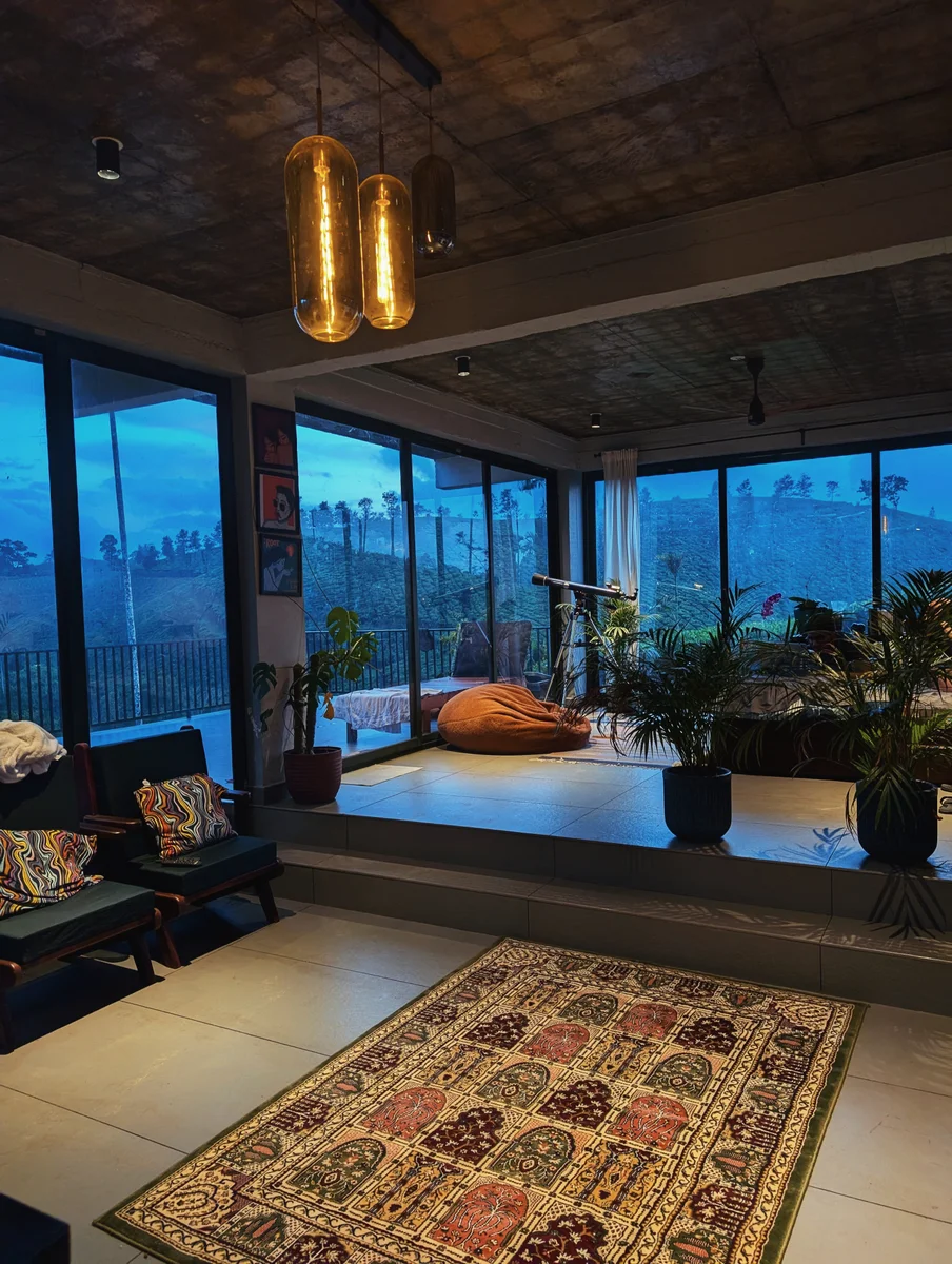 A glass-walled living room at twilight